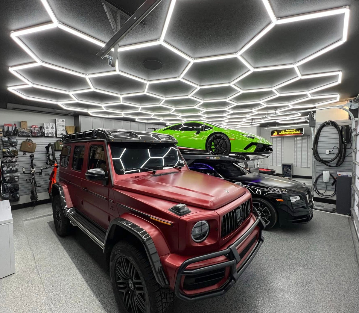 Garage with a red G-Wagon and a green Lamborghini under a HexGlow hexagon ceiling